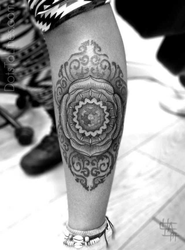Amazing sacred geometry tattoo by Chaim Machlev of a mandala flower with a dotwork cube