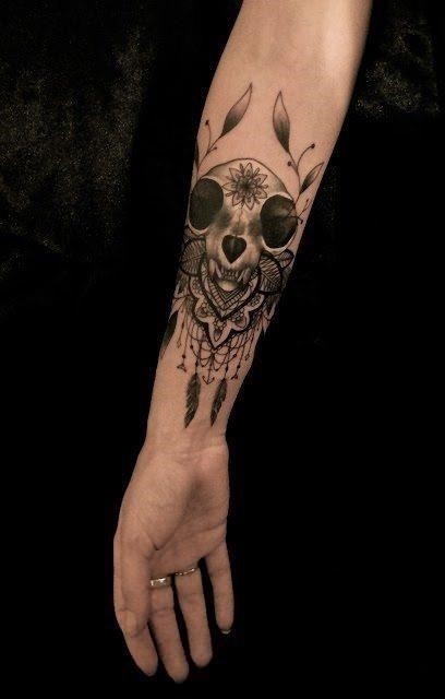An animal skull with lace beads and feathers becomes a feminine tattoo design by Dodie