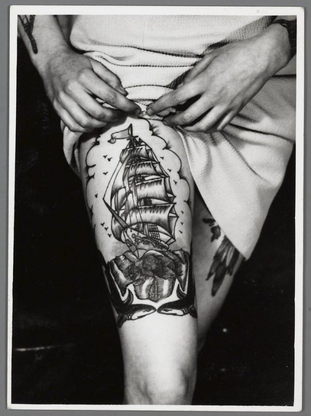 Black and white ship tattoo on leg