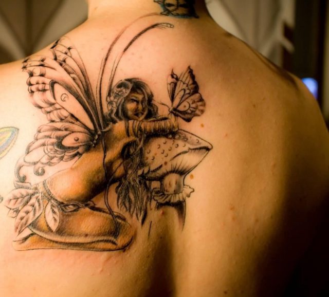 Classic Fairy On Mushroom With Butterfly Tattoo On Upper Back