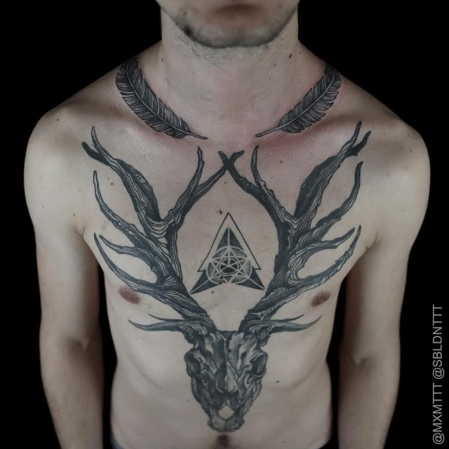 Grey Ink Feathers And Deer Skull Tattoo On Man Chest