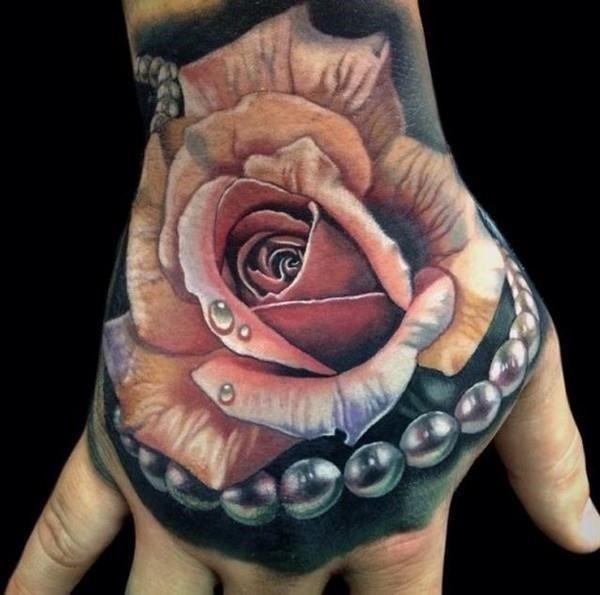Pink realistic rose and pearl tattoo on upper hand