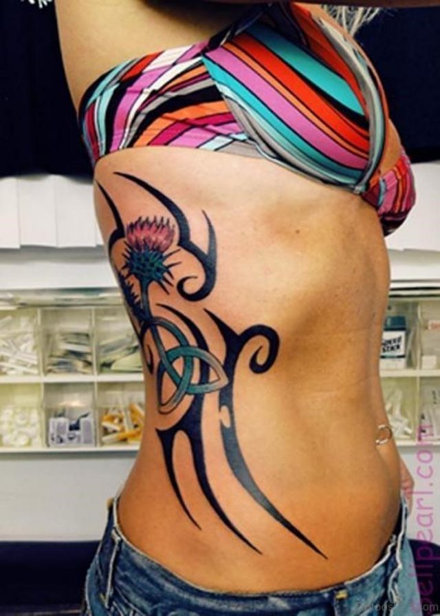 Tribal Flower And Irish Knot Tattoos On Side Of Rib