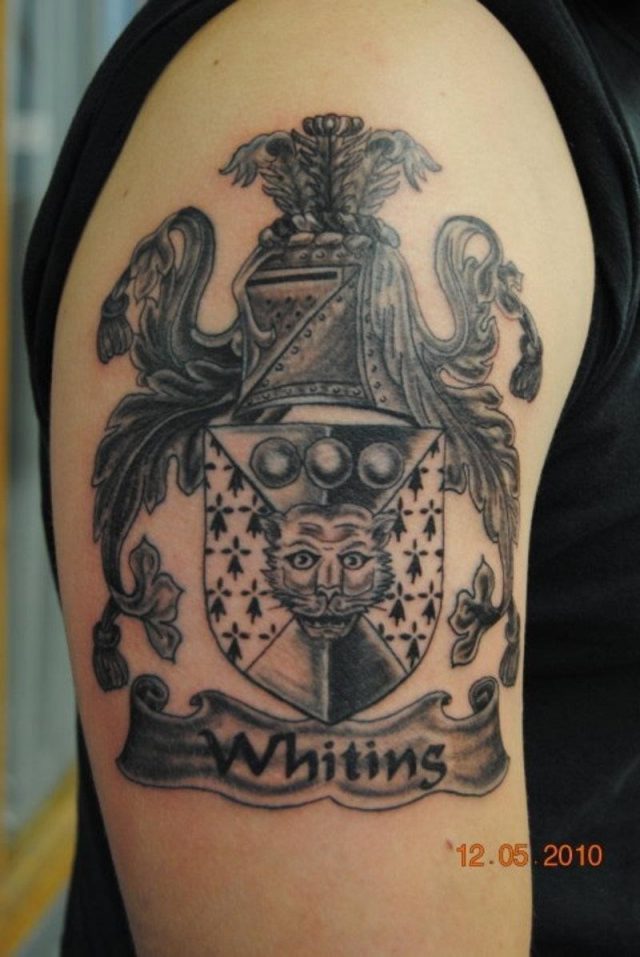 Beautiful grey ink half sleeve family crest tattoo