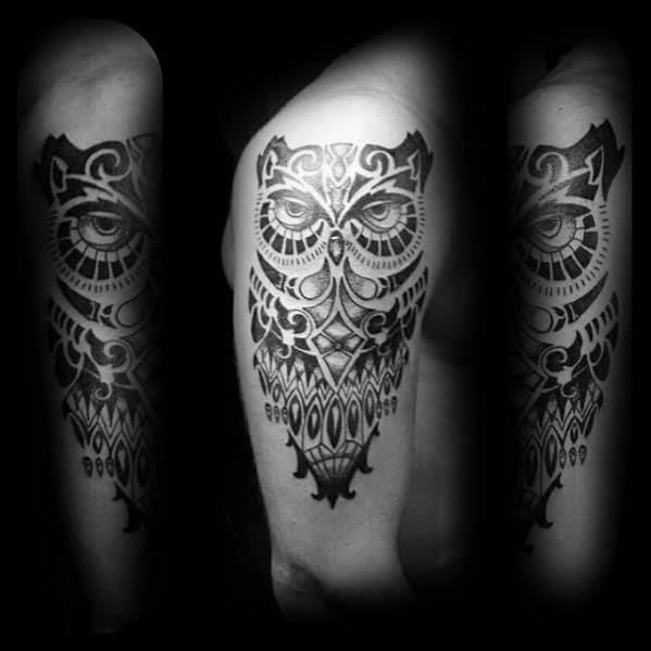 Black and grey tribal owl arm tattoo on gentleman