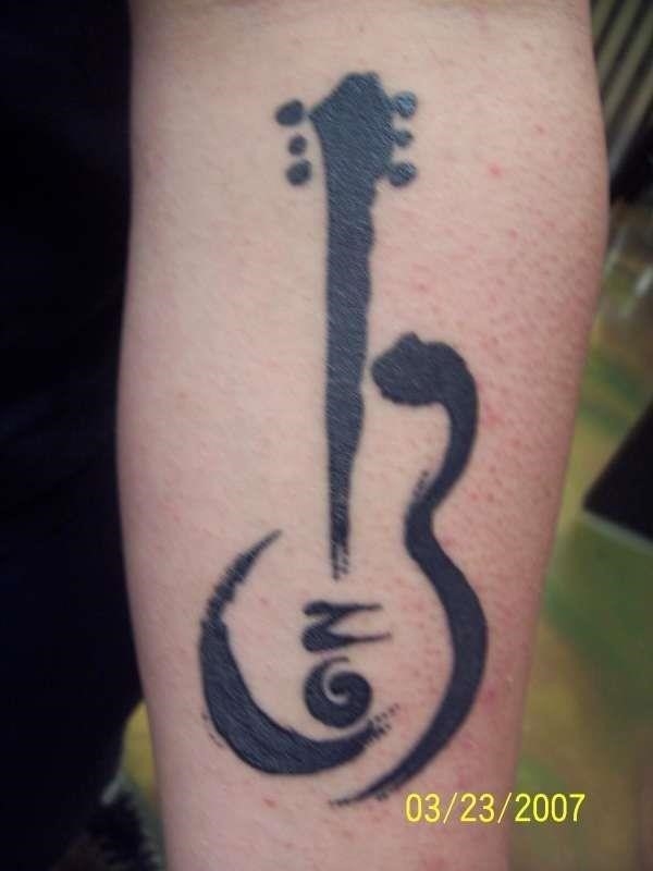 Black tribal guitar tattoo on left sleeve