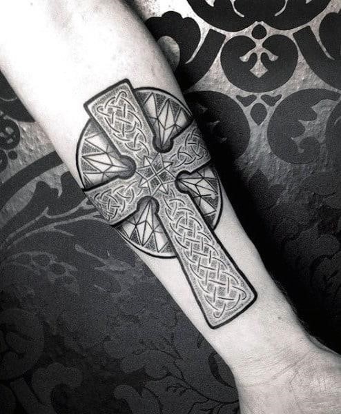 Celtic cross tattoo on mans inner forearm