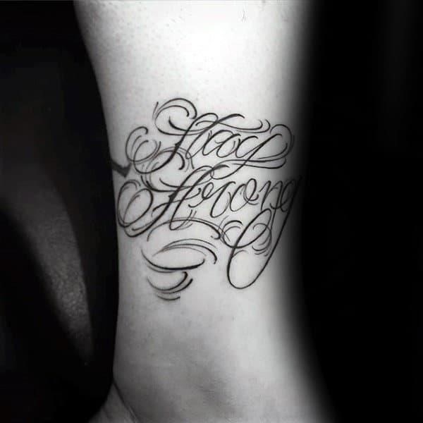 Cursive ornate male strength stay strong tattoo on forearm