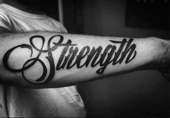 Gentleman with black ink strength word tattoo on outer forearms
