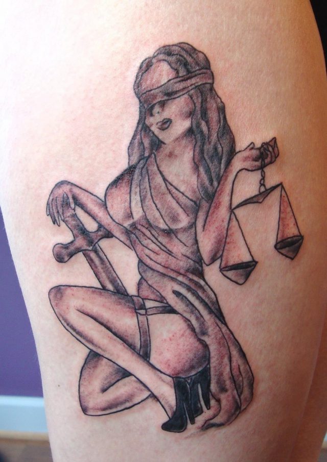 Girl with cross and balance justice tattoo