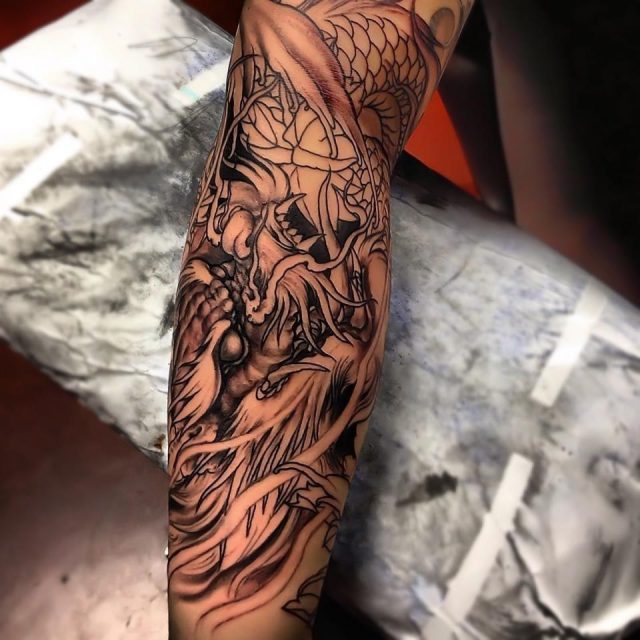 Grey ink asian tattoo on right sleeve