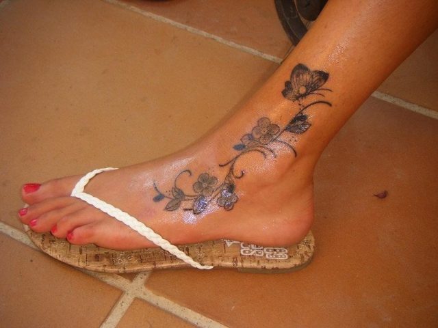 Grey ink flowers and butterfly foot tattoo