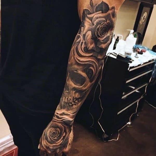 Guy with cool rose and skull tattoo forearms