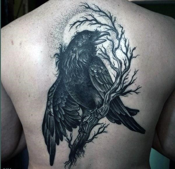 Hairy dark raven on a twig tattoo male back