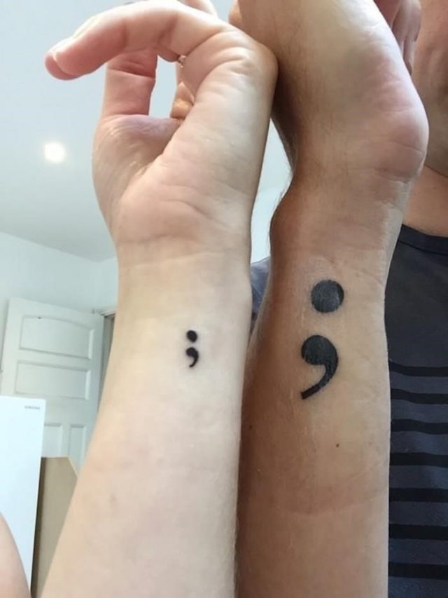 Male and female hand placed side by side sporting a small and a larger black semi colon tattoos suicide awareness tattoo matching designs