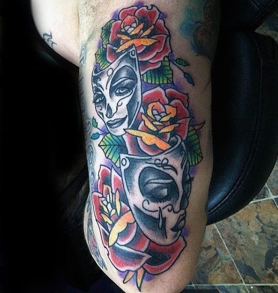 Male with roses and colored masks tattoo on triceps