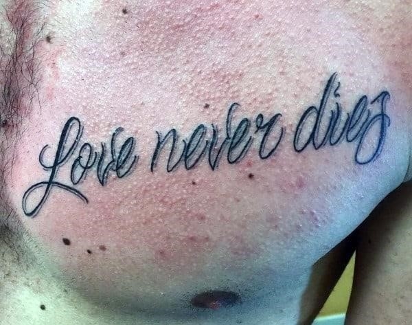 Male with tattoo of script love never dies on chest