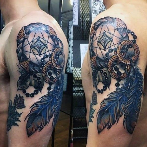 Man with blue feather dreamcatcher upper arm tattoos