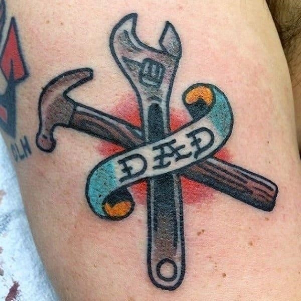 Man with tools and dad tattoo on forearm