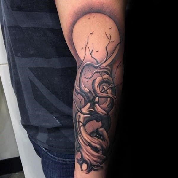 Moon with family tree male outer forearm tattoo