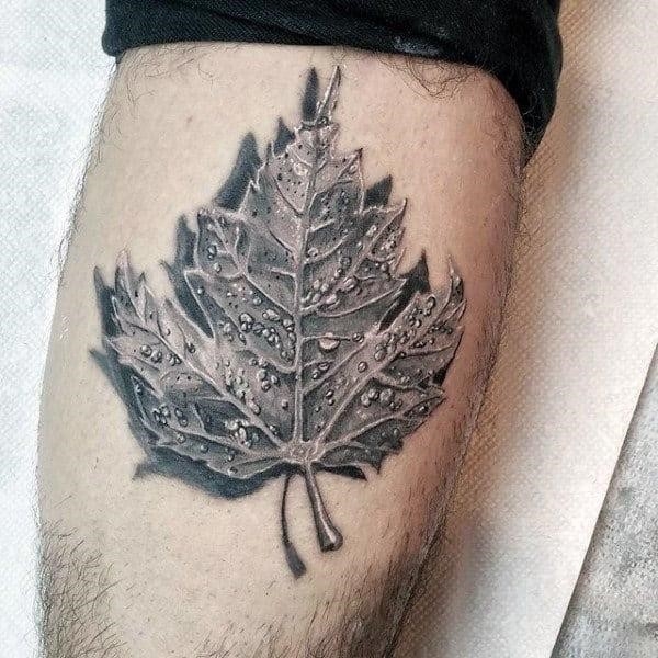 Realsitic 3d maple leaf shaded black and grey tattoo on arm