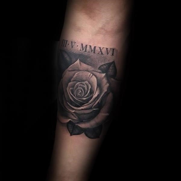 Rose flower with roman numeral tattoo on mans inner forearm