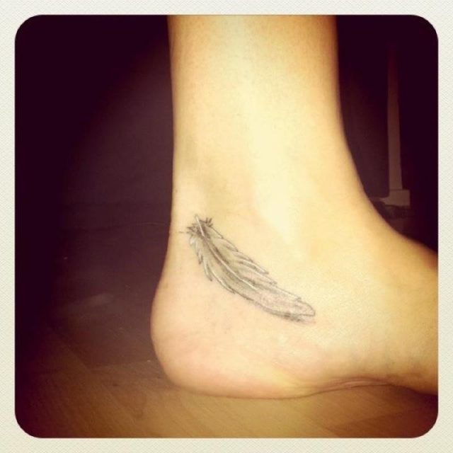 Small feather tattoo below ankle