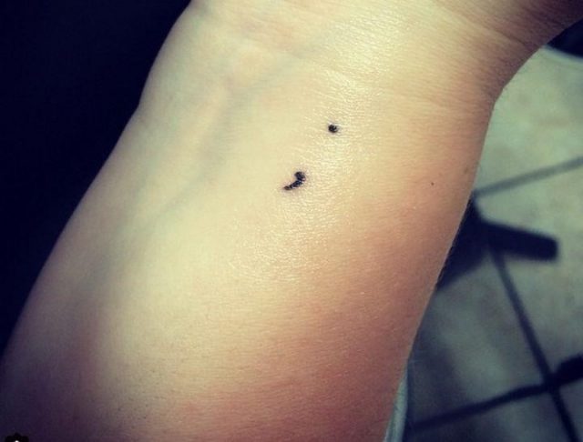 Small semicolon hand tattoo