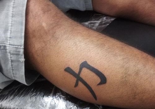 Strength symbol leg tattoo