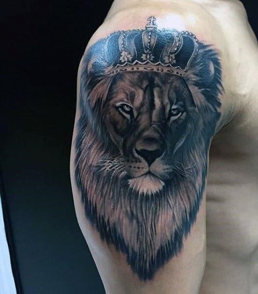 Upper arm lion king tattoo for males with crown
